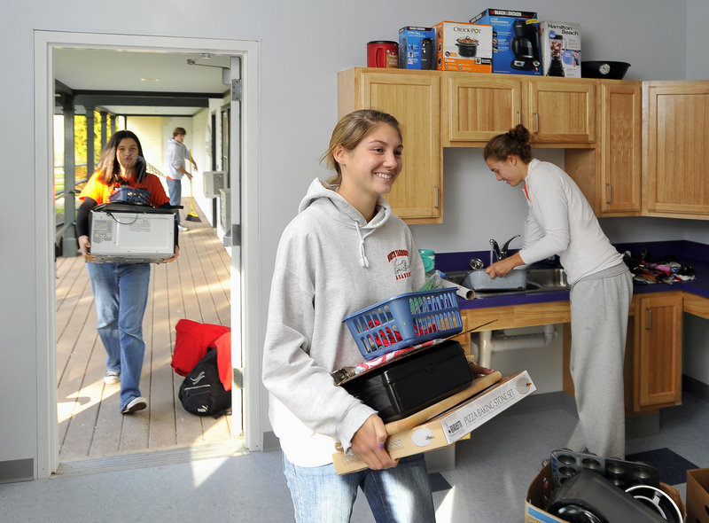 A small army of students from North Yarmouth Academy volunteers at the new Boys and Girls Club in Sagamore Village on Wednesday as part of Project: Reach Out. Here, 16-year-old Moira Lachance, center, carries a box filled with kitchen supplies, followed by Hennah Look, 13, who is lugging a new microwave oven. On the right is Sarah Burkey, 17, who volunteered to put away all the items around the sink. Sweeping the porch, background left, is Josiah Henderson, 14. North Yarmouth students traveled from Portland to Bath to Lewiston-Auburn to participate in community service projects, which included clearing trails, yardwork and planting trees. The success of Project: Reach Out last spring convinced school officials to make the event a biannual occurrence.