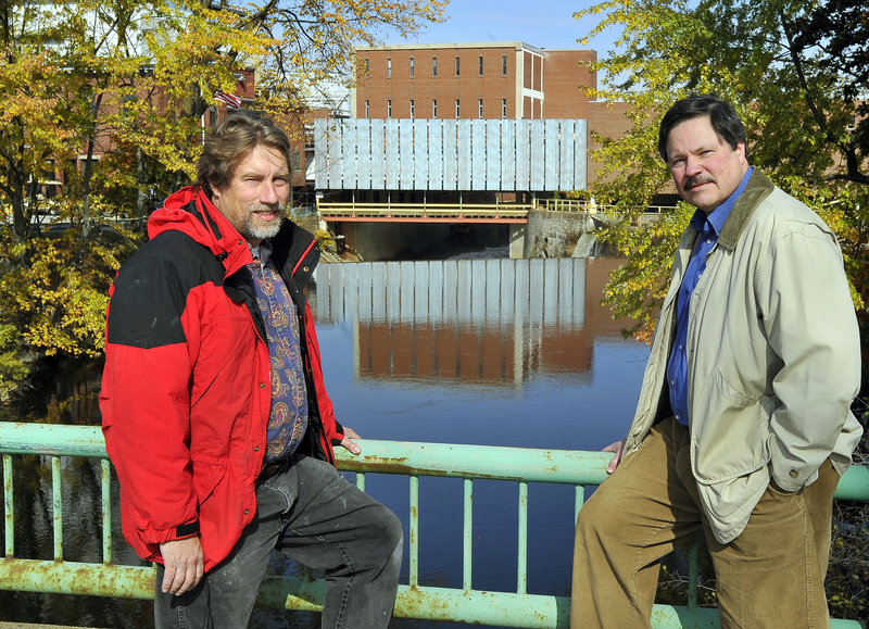 The founders of Friends of the Presumpscot River, Mike Shaughnessy and Will Plumley, frame the dam at Sappi in Westbrook that will soon have a passageway for fish.