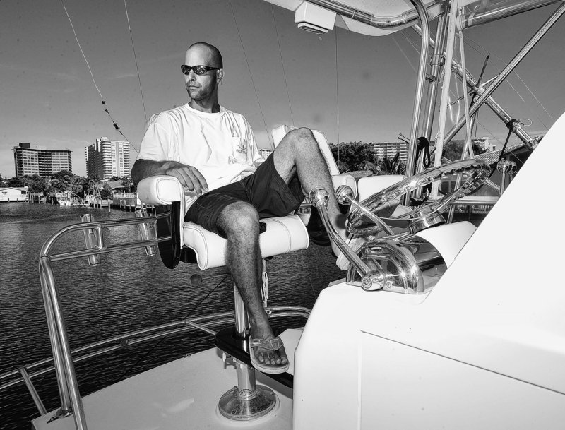 Former mortgage industry executive Jason Altneu, seen in South Florida on his boat last August, now has two jobs – charter boat captain and independent insurance agent – as many professionals look for new fields because their old career paths have disappeared.