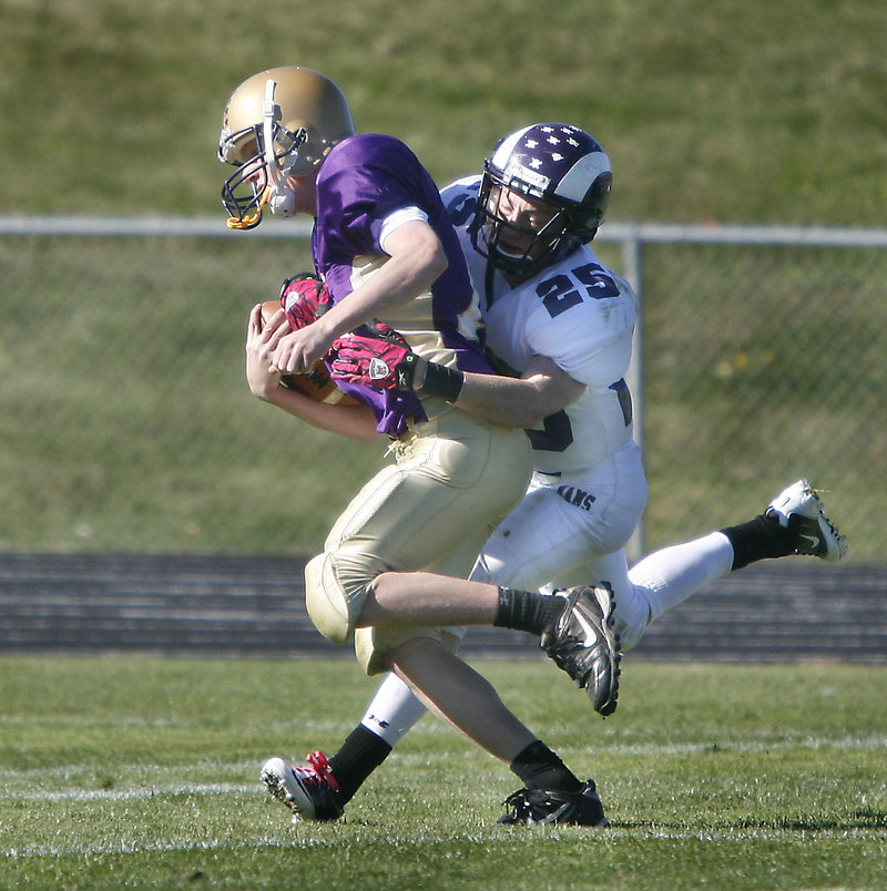 Liam Fitzpatrick of Cheverus carries Trey Thomes of Deering into the end zone Saturday after catching a first-quarter pass. Cheverus earned a 44-14 victory at home.
