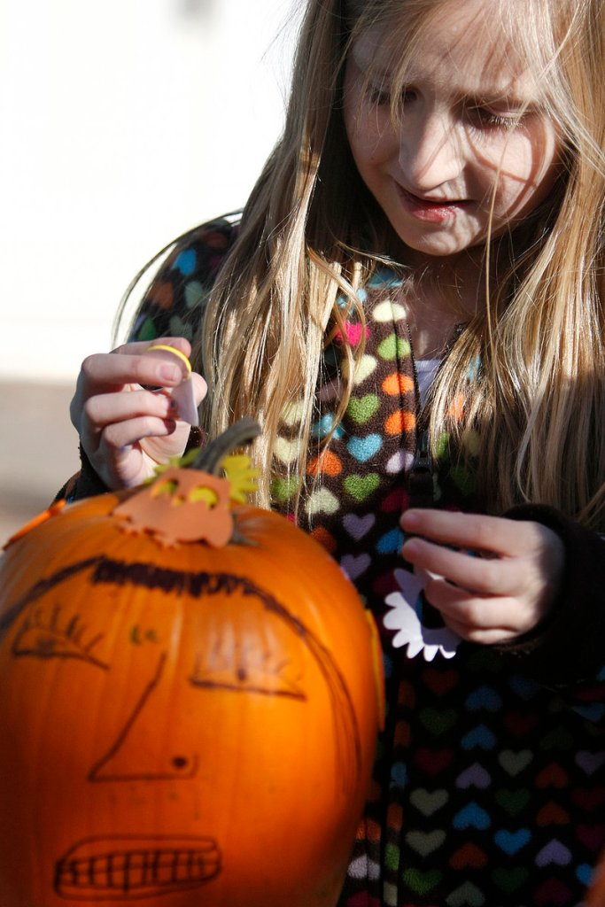 Briana Simpson, 9, of Wells decorates a pumpkin at Cafe Amore on Saturday.