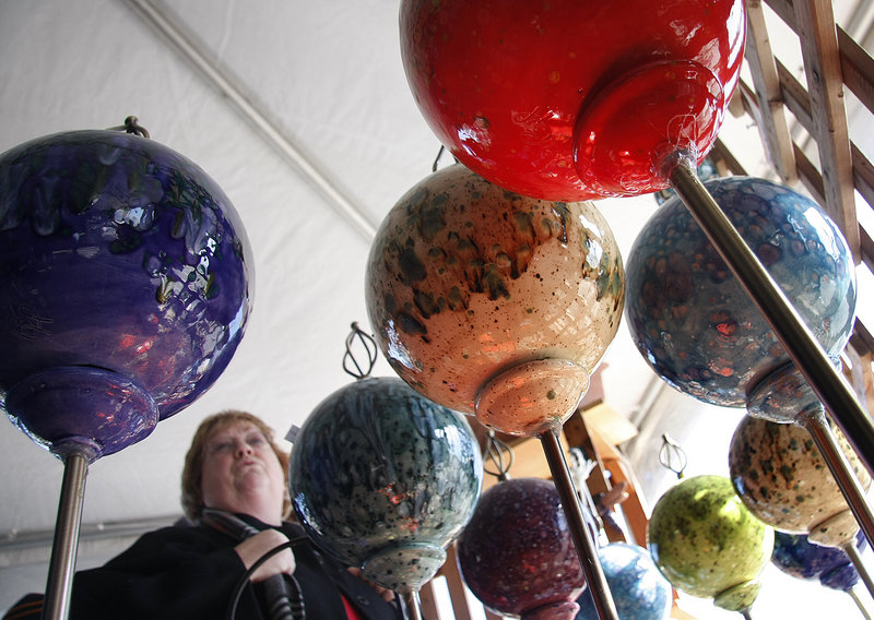 Nancy Baker of Wilmington, Vt., looks over colorful clay garden globes for sale in OgunquitFest's Autumn Bazaar. The globes and other garden ornaments are made by artist Bernadette Henry of Cape Neddick.