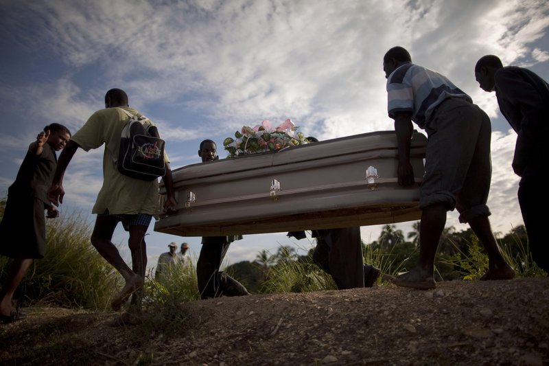 Haitians carry a coffin containing the remains of a relative who died of cholera in Robine, Haiti, on Saturday. A cholera outbreak threatens to outpace aid groups hoping to keep the disease from reaching the camps of earthquake survivors in Port-au-Prince.
