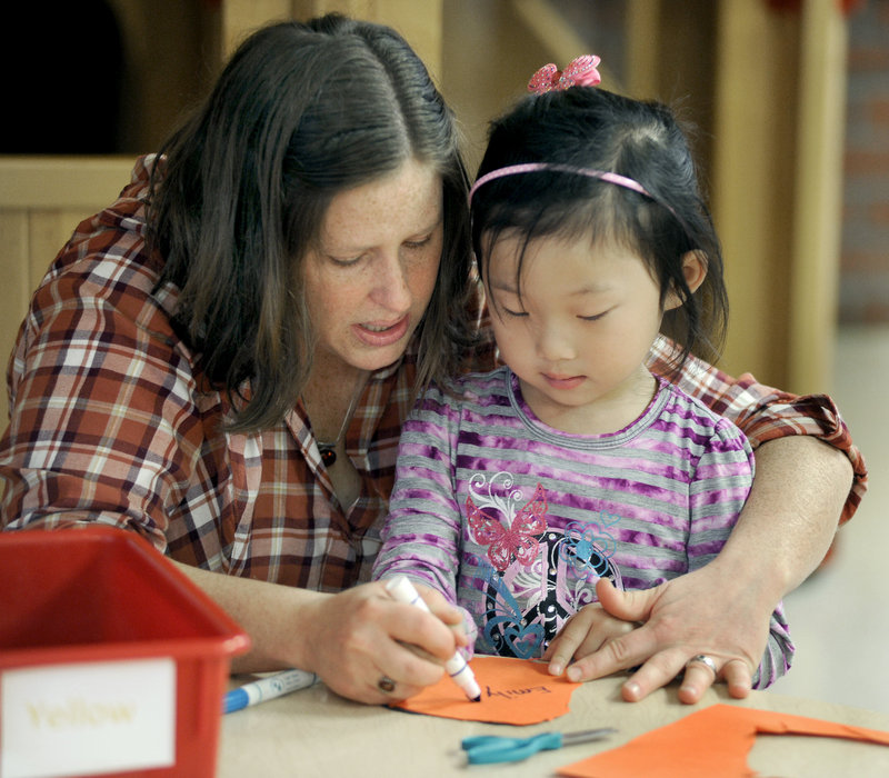 Teacher Carrie Garrett, a certified preschool instructor from Catherine Morrill Day Nursery, works Monday with 3-year-old Emily Talbot in the Early Learning Center at PATHS.