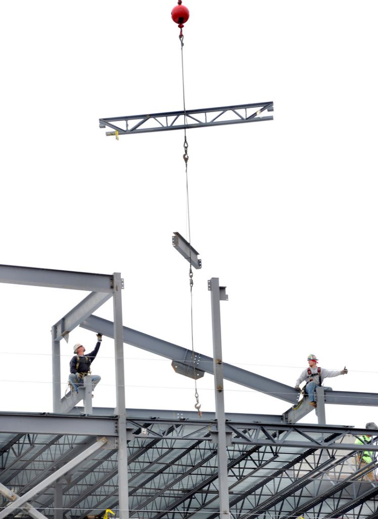 Iron workers Dillon Nutting, left, and Danny Twombly connect sixth-floor steel beams at the former Jordan’s Meats site in Portland on Monday. The new building will house a hotel, restaurant and condos.