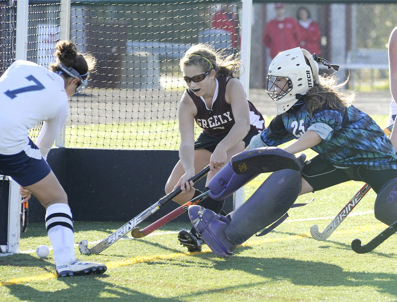 Chelsea Morley of York, left, attempts to put the ball over the line Tuesday as Meaghan Labbe and goalie Hannah McCord defend for Greely. York won Western Class B, 3-1.