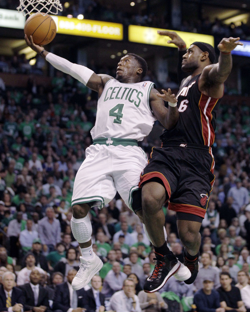 Nate Robinson of the Boston Celtics holds off LeBron James and heads to the basket Tuesday night during the first half of the 88-80 season-opening victory against the Miami Heat.