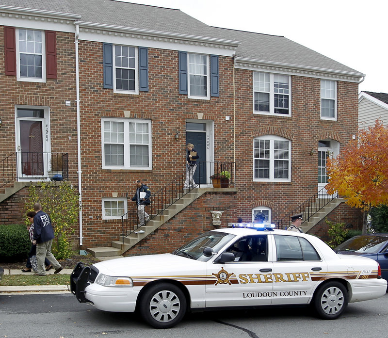 FBI and law enforcement investigators leave the home of Farooque Ahmed in Ashburn, Va., on Wednesday. Ahmed, who emigrated to the U.S. in 1993 and later became a citizen, is charged with trying to help people he believed were al-Qaida operatives planning to bomb subway stations around the nation’s capital, the FBI said.