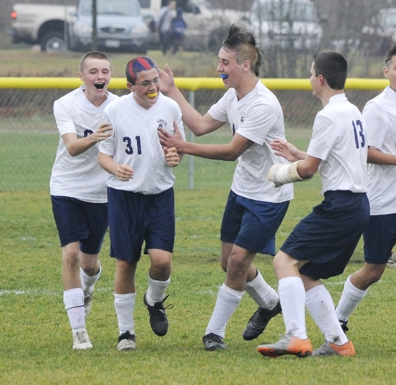 Sam Whiting of Greater Portland Christian is welcomed by teammates after scoring a goal in the second half.
