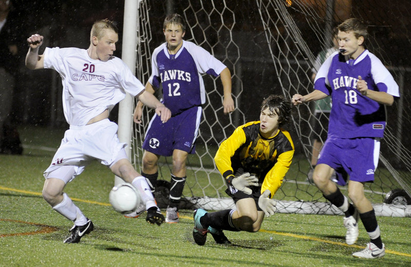 Paul Wennberg of Cape Elizabeth, left, provides a screen Wednesday night as a shot by teammate Blake Barritt skips through for a goal. Defending for Marshwood are goalie Jackson Towle, with Thomas Kent, 12, manning a post. Cape Elizabeth won 5-0 at home.