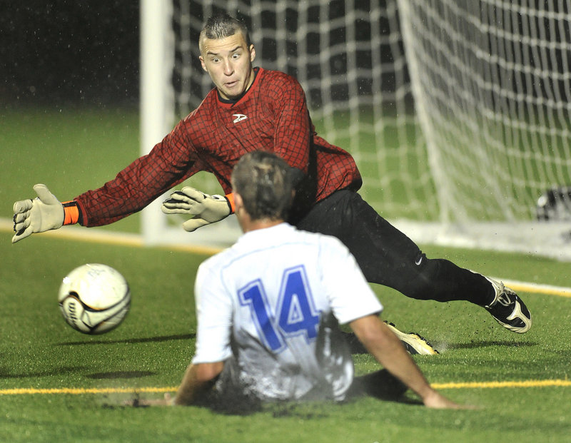Gray-New Gloucester goalie Ryan Cavallaro dives to stop a shot by Michael Bloom of Falmouth in the first half of Falmouth s 1-0 victory Wednesday.