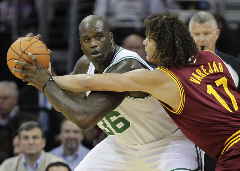 Anderson Varejao of the Cavaliers, right, tries to poke the ball away from Shaquille O’Neal of the Celtics during Cleveland’s 95-87 victory in its season opener Wednesday night.