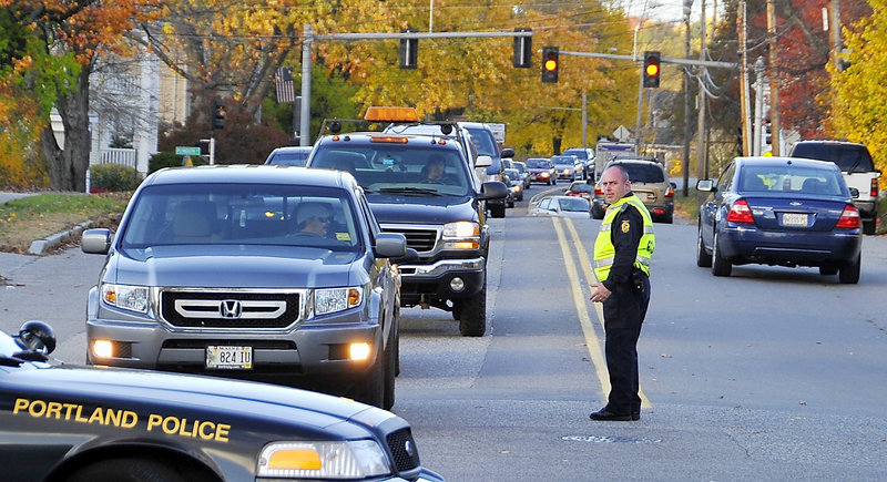 Traffic backs up Thursday at the Allen Avenue crossing as a train slowly passes. Officer Chris Coyne told drivers they could wait 45 minutes or find another route.
