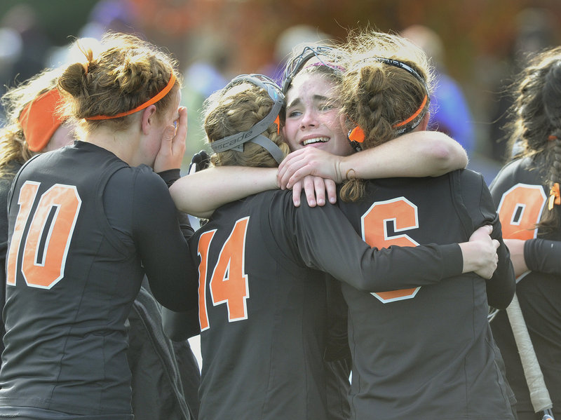 Kylie Dalbec hugs two North Yarmouth Academy teammates Saturday after the Panthers captured the Class C field hockey title by beating Foxcroft Academy.