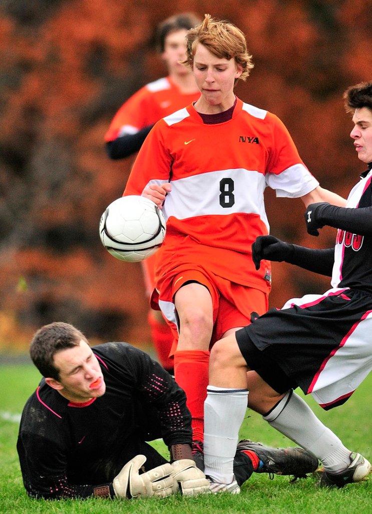 North Yarmouth Academy keeper Jordan Zembroski, left, blocks a shot by Hall-Dale s Kevin Zembroski, right, as NYA s Jackson Cohan-Smith tries to clear the rebound.