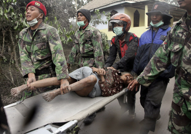 Indonesian soldiers evacuate an elderly woman who refuses to leave her house in Ngerangkah, Yogyakarta, Indonesia, on Saturday. Indonesia’s military forced villagers off the slopes of the country’s most volatile volcano Saturday as it unleashed a new powerful explosion.
