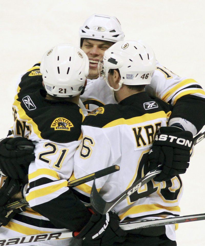 David Krejci, right, celebrates with Nathan Horton, back, and Andrew Ference after scoring a first-period goal for the Bruins in a 4-0victory over the Ottawa Senators Saturday night at Ottawa.