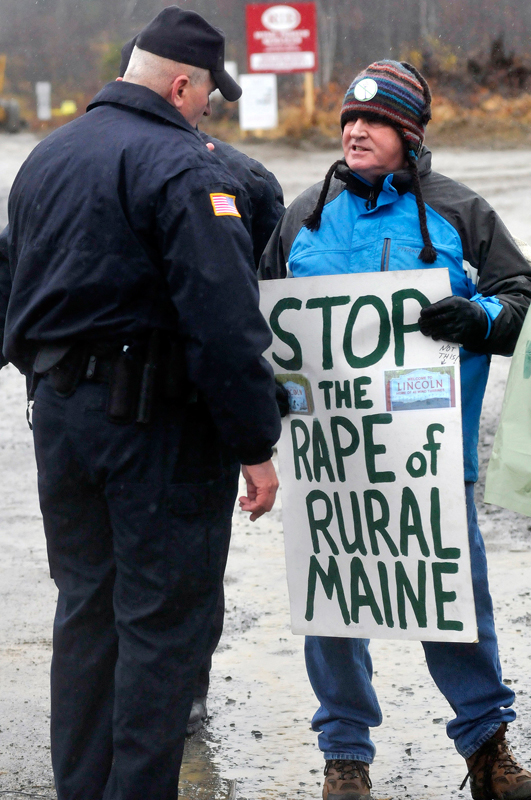 Protester Brad Blake of Portland who was with Friends of Lincoln Lakes is asked by a police officer to move off the property at the Rollins wind energy project in Lincoln Monday, Nov. 8, 2010.