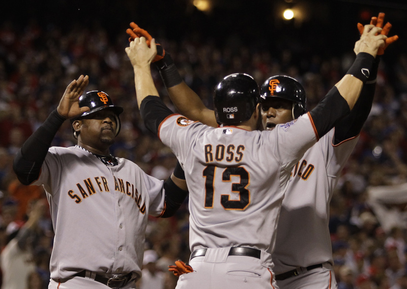 Cody Ross greets Edgar Renteria after Renteria hit a three-run homer in the seventh that gave the Giants the runs to win the game and clinch the World Series.