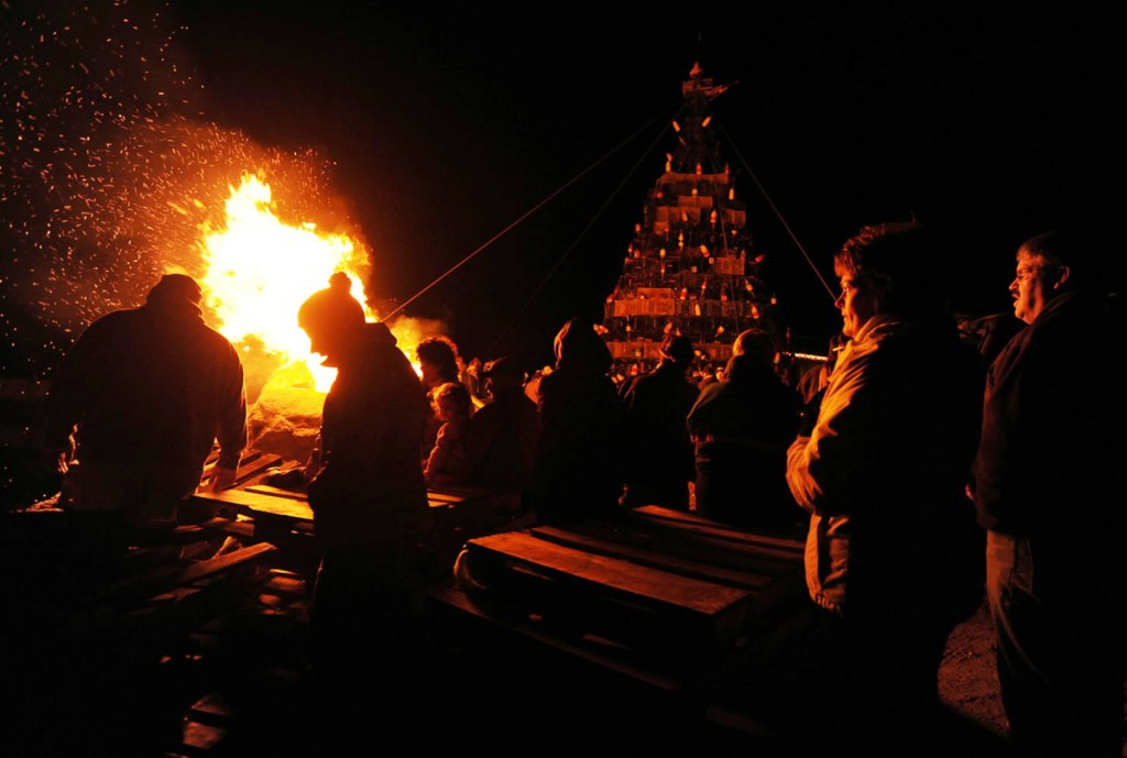 People gather on Beals Island Sunday to watch the lighting of a Christmas tree constructed of lobster traps and buoys.