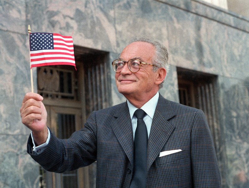 Film producer Dino De Laurentiis holds an American flag outside the Los Angeles Federal Courthouse after becoming a U.S. citizen in 1986. A producer of "Serpico," "Barbarella" and "Death Wish," he died Wednesday at age 91.