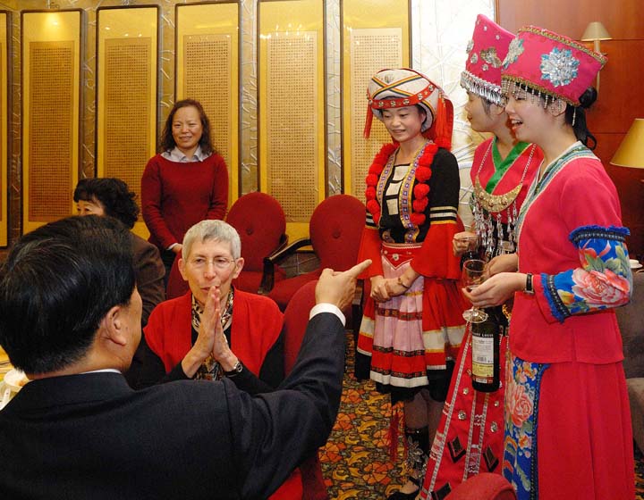 Theodora Kalikow (seated, center), president of the University of Maine at Farmington, listens to an explanation of Yao minority customs as described by her host, Hou Yibin, vice president of Beijing University of Technology, at a banquet honoring BJUT’s friendship with UMF.
