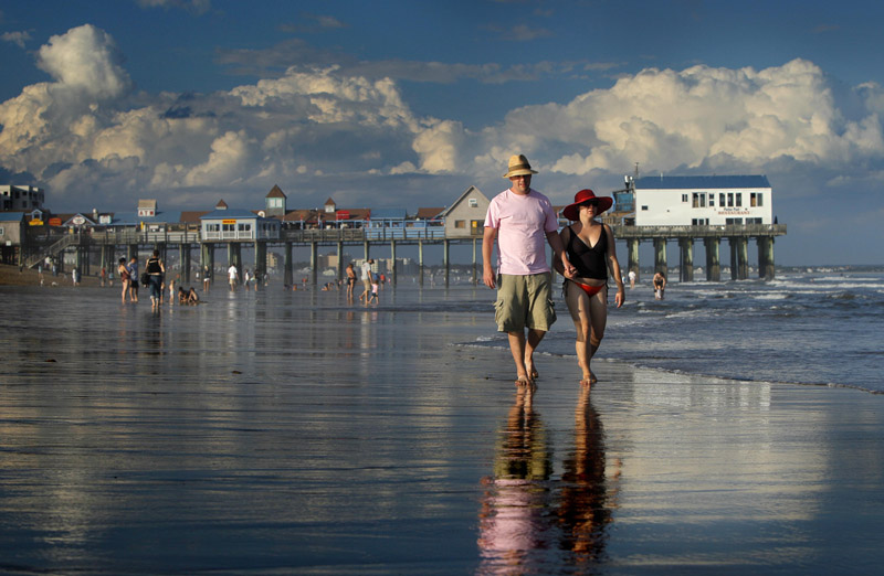 In this Aug. 26, 2010, photo, Dan Horner, left, and Cynthia Belaskie, of Toronto, stroll along the ocean in Old Orchard Beach.