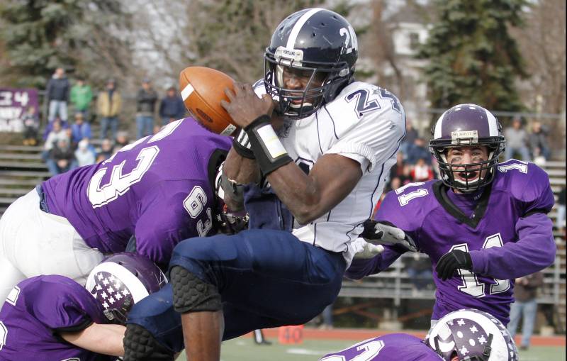 Imadhi Zagon of Portland fumbles Thursday while absorbing a hard hit from Jake Totman, 63, of Deering. Also in on the play for the Rams are Trey Thomes, 25; Devon Fitzgerald, 32; and Matt Flaherty, 11. Deering won the Thanksgiving Day game, 35-14.
