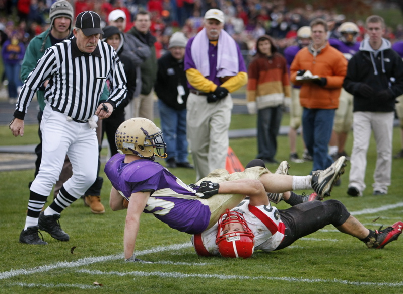 Jack Bushey of Cheverus is grabbed by Scarborough's Mark Pearson after a fourth-down conversion that led to the winning touchdown in the fourth quarter Saturday in the Western Class A semifinal football game at Cheverus. Cheverus won, 21-14.