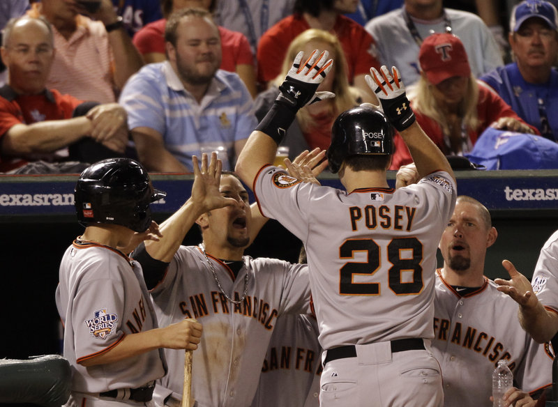 Buster Posey is congratulated by his teammates after hitting a solo home run in the eighth inning to give the Giants a 4-0 lead. San Francisco needs a win tonight to finish the series.