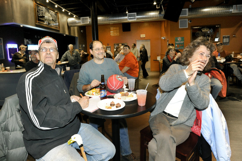 Charlie Morse of Gray, left, and Nick and Angie Palestini of Portland cheer Maine’s picks at Binga’s Wingas in Portland while watching the NBA Development League draft Monday.