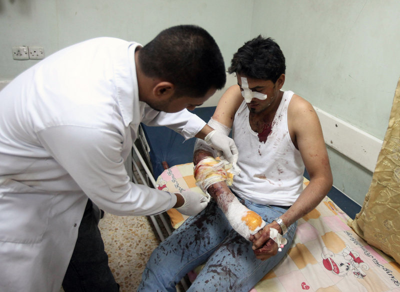 A wounded man is treated after a bombing in the Shiite neighborhood of Sadr City in Baghdad on Tuesday. Rapid-fire bombings and mortar strikes in mostly Shiite neighborhoods of Baghdad killed up to 76 and wounded hundreds, increasing doubts about the ability of Iraqi security forces to protect the capital.