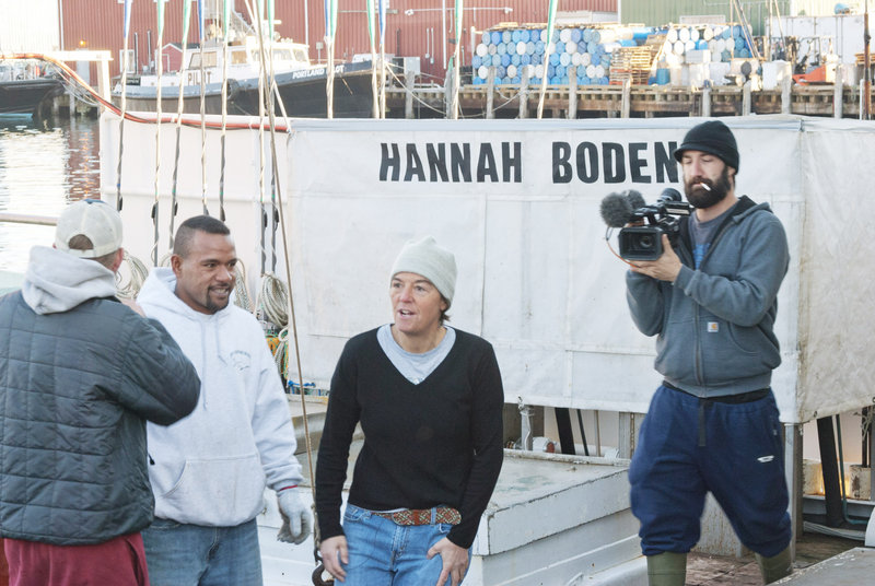 Linda Greenlaw, center, who captains the Hannah Boden, speaks to members of her crew after docking the sword boat at the Portland Fish Exchange on Wednesday morning. A Discovery Channel videographer, right, records the scene.