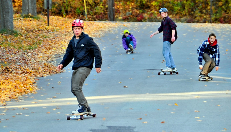 Oliver Nolan, 14, leads the pack as he and friends enjoy the colorful autumn weather to skateboard down a quiet neighborhood street in Portland near the Brighton campus of Maine Medical Center. Boarding with him are, left to right, Isaac Santerre, 14, Zack Roland, 14, and Dana Kuniholm, 15.
