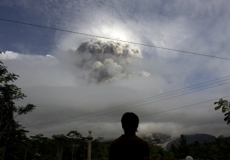 A man watches Wednesday as Mount Merapi erupts in Indonesia. The country is prone to volcanic activity because it sits along a string of faults in the Pacific Ocean region.