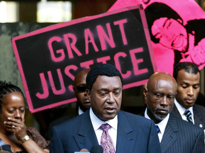 Oscar Grant’s family attorney John Burris, center, and uncle Cephus Johnson, right, comment Friday on the two-year sentence given to Johannes Mehserle, a white ex-transit officer, for killing Grant at an Oakland, Calif., train station.