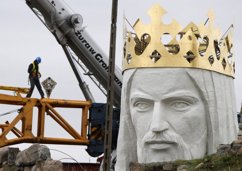 Workers struggle against the wind Friday to assemble a crane that is to lift the 32-ton head and shoulders atop a giant concrete and metal statue of Jesus in Swiebodzin, Poland. Another effort to complete the project will take place today.