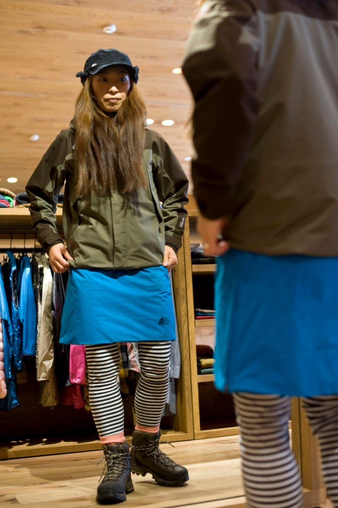 Minako Yoshikoshi, who works at Tokyo’s North Face Harajuku store, tries on clothes popular with the growing number of women who are taking to the hills of Japan wearing short pants or fleece skirts with leggings and designer trekking boots.