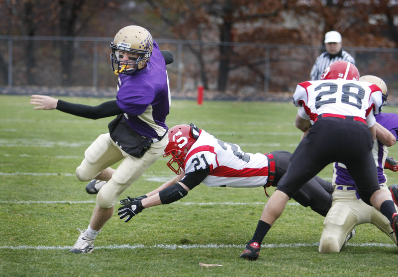 Cheverus quarterback Peter Gwilym zips past a dive by Kellen Smith of Scarborough during a first-half run Saturday.