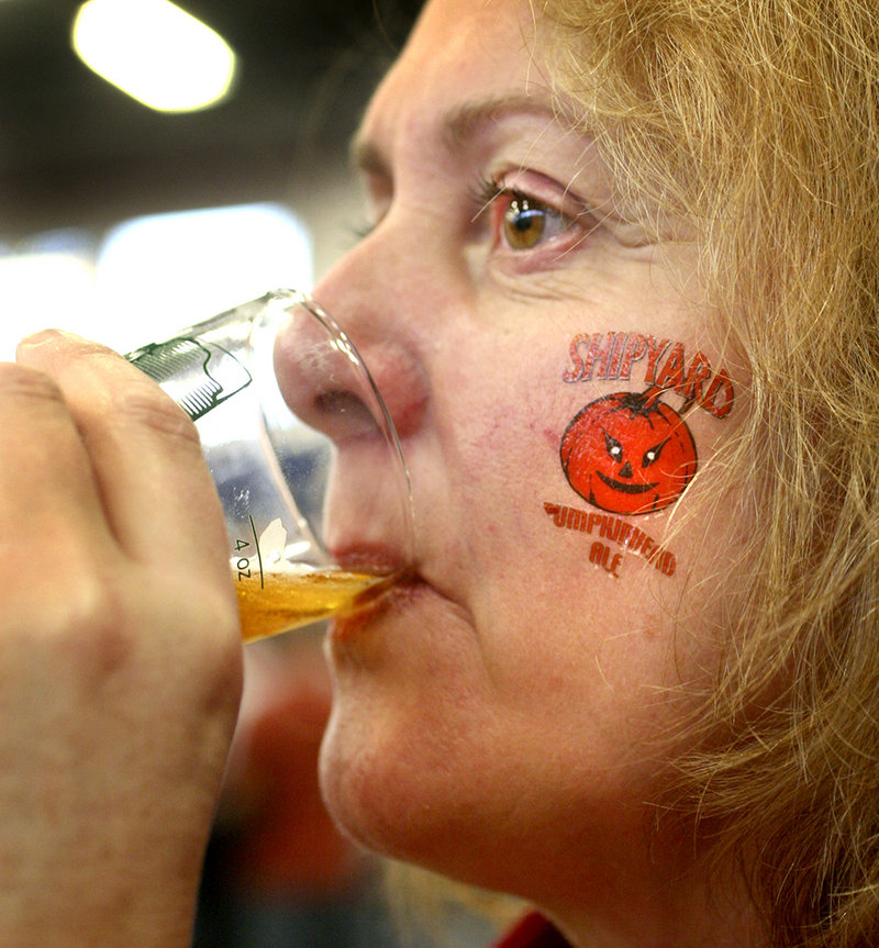 Mary Fowler of New Brunswick, Canada, sports a temporary tattoo from Shipyard Brewery as she samples Sunday River IPA. Hundreds of beer fans paid $32 for entry to the Portland Expo to drink 12 4-ounce samples.