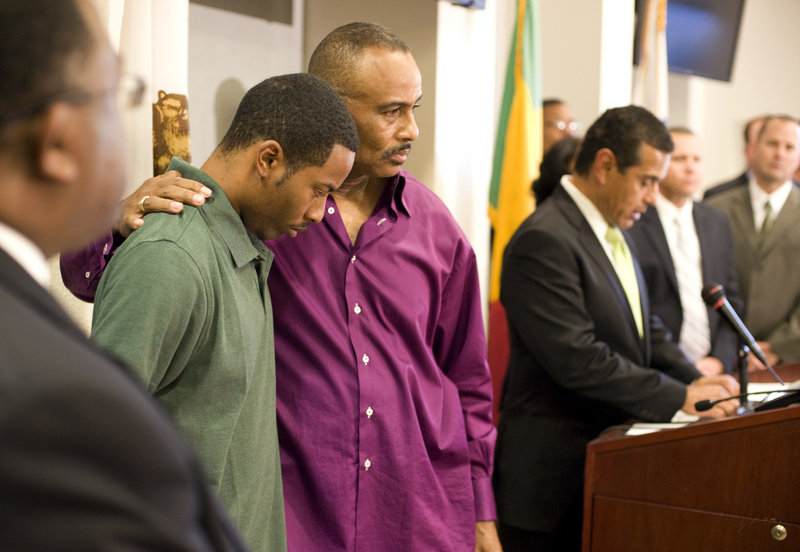 Aaron Shannon Sr., left, is comforted by his father, William, during a police news conference in Los Angeles Friday. Two alleged gang members were arrested Friday in 5-year-old Aaron Shannon Jr.'s killing. Shootings of children in misdirected gang gunfire have become rare.