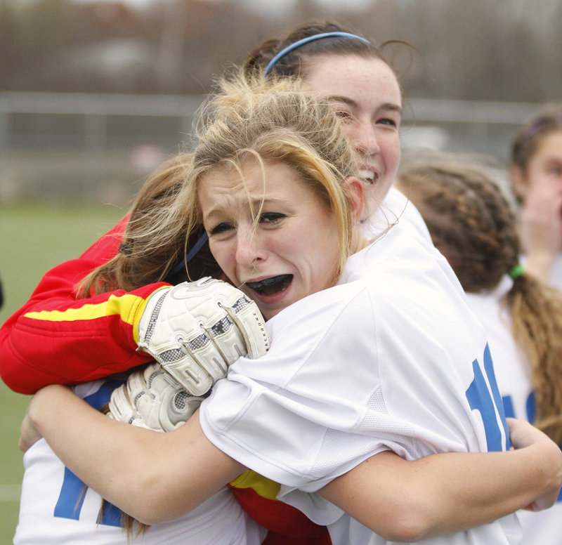 Alexis Toolin shares a winning embrace with teammates Emily Lane, left, and goalie Courtney Ross after Sacopee Valley won the Class C title in OT.