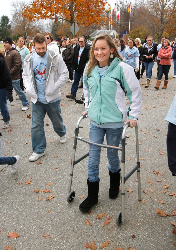 Ashley Dubois demonstrates her recovering mobility as she finishes a walk organized for her benefit in Kennebunk on Sunday. The event raised an estimated $17,000 to help with Dubois' ongoing medical expenses following a car accident in September. Local businesses donated money and raffle items for the walk, which was conceived and organized by some of Dubois' classmates.