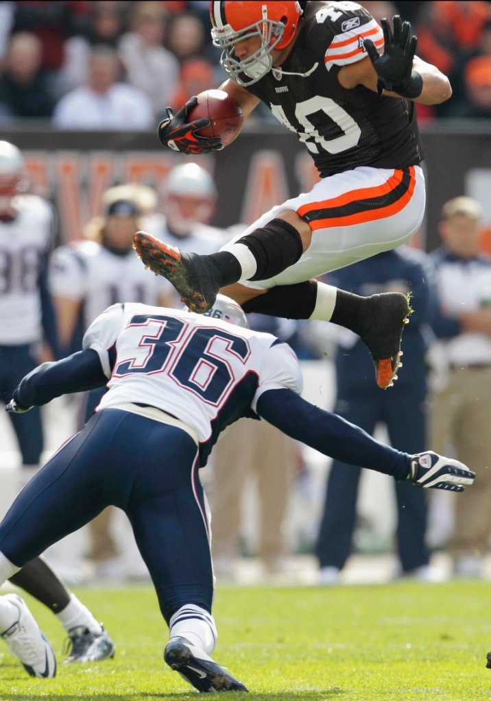 Cleveland running back Peyton Hillis leaps over New England safety Josh Barrett during the Browns’ dominating 34-14 victory Sunday in Cleveland. Hillis rushed 29 times for 184 yards and two touchdowns.