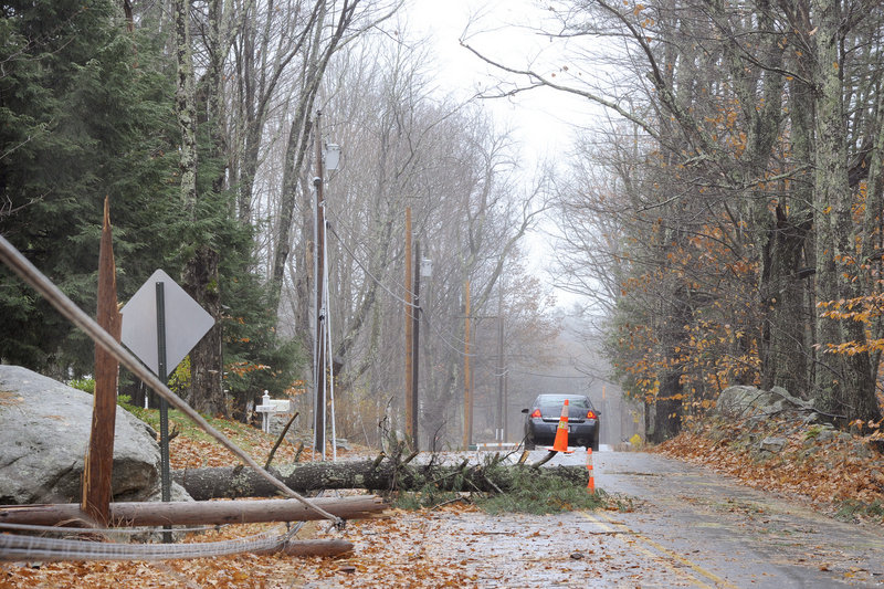 Motorists are able to pass on one side of the Campbell Shore Road in Gray Monday after a large pine tree broke a utility pole and snapped wires during Sunday night’s wind and rainstorm. Winds reached 45 mph overnight in Gray.