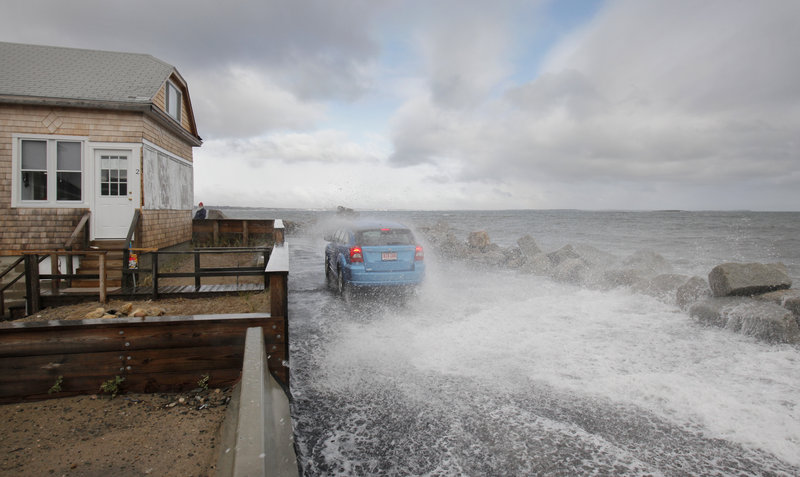 Waves douse a car on Eastern Avenue in Camp Ellis on Monday.