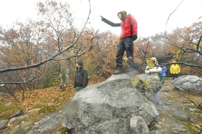 Emily Baisden, a University of New England student, looks at the scenery from atop a rock on Burnt Meadow Mountain in Brownfield on a rainy day earlier this month.