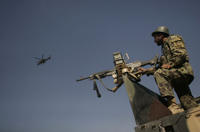 A NATO helicopter hovers near an Afghan soldier in October. The Afghan army and police force still face enormous challenges as education for enlistees and corruption have conspired to create high attrition. Canada says it will extend its mission in Afghanistan to train the forces.