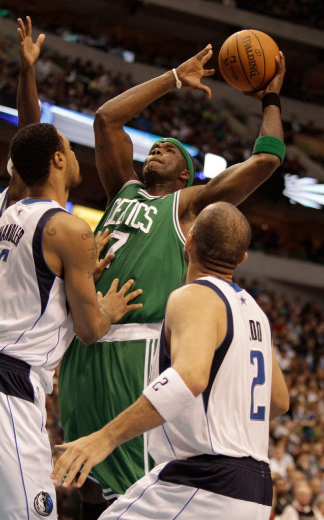 Boston’s Jermaine O’Neal takes a shot over Dallas’ Tyson Chandler, left, and Jason Kidd during the first half of their game Monday night in Dallas. The Mavs won, 89-87.