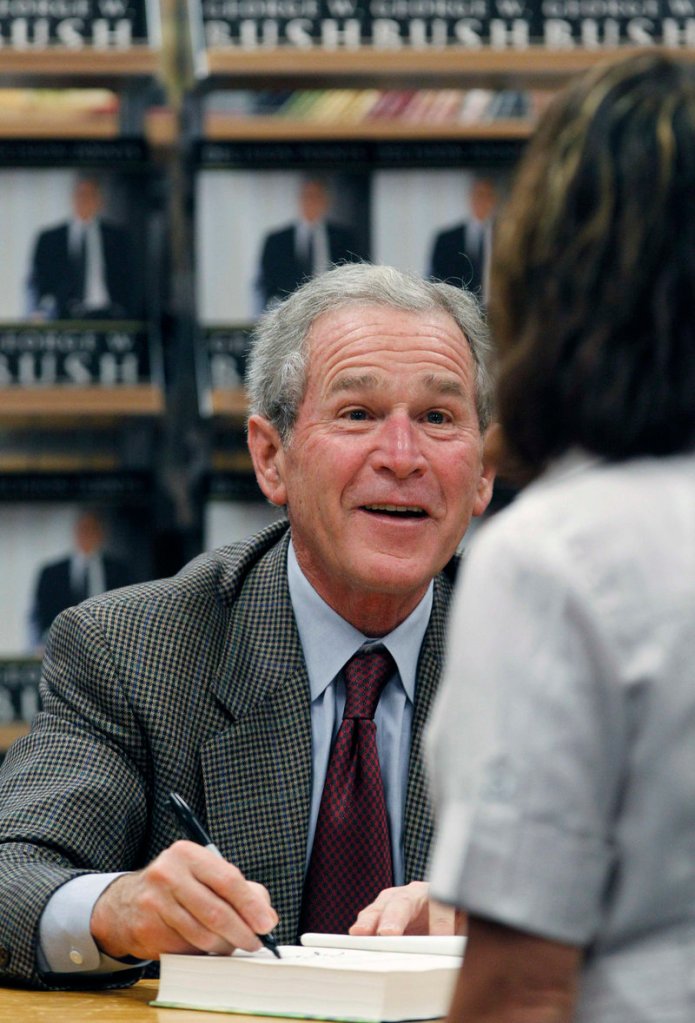 Former President George W. Bush signs a copy of his book “Decision Points” at a bookstore in Dallas on Tuesday. A long line of fans gathered earlier to get an autographed copy.